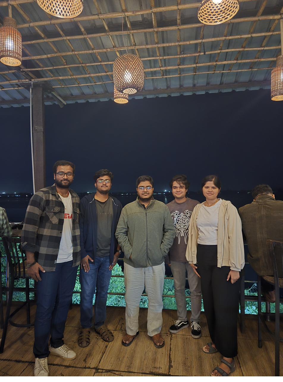 Five members of the Biosensing and Biophysics Lab on a restaurant deck at night.