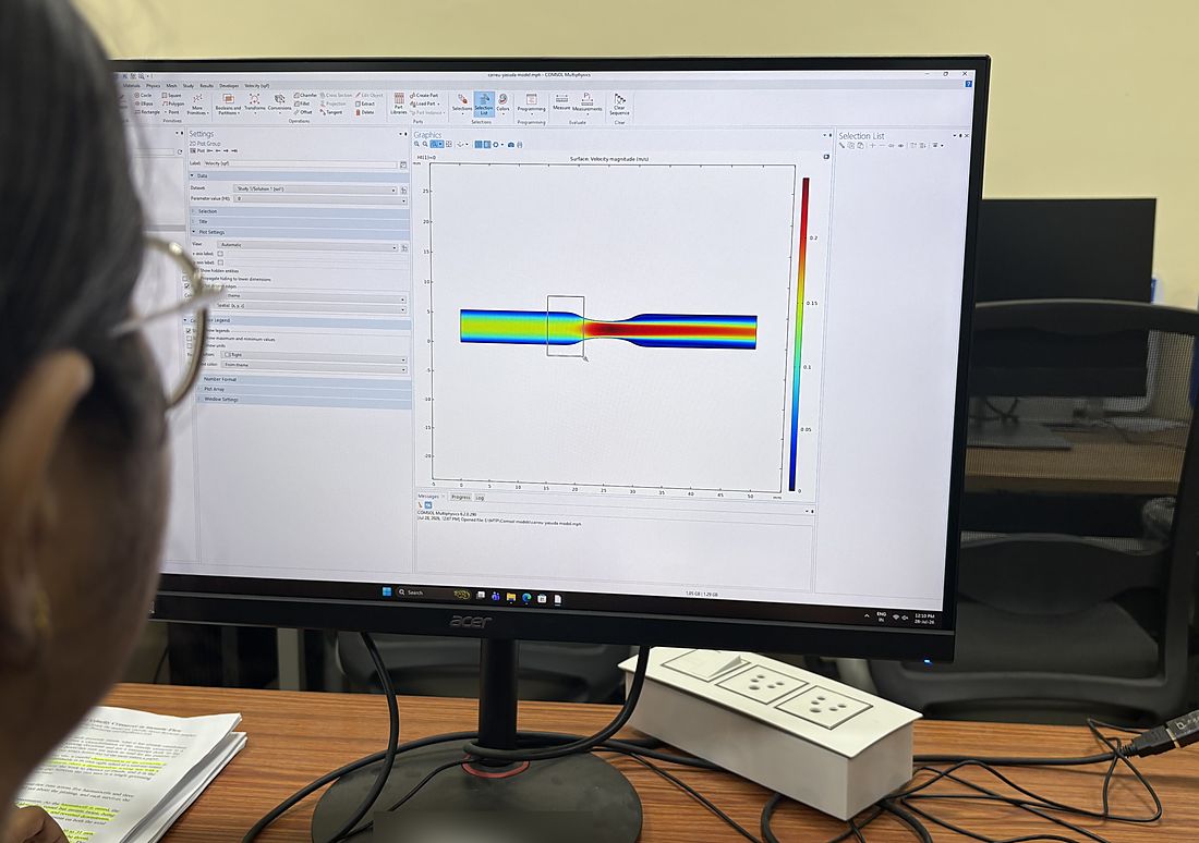 A COMSOL Multiphysics window showing the velocity field of blood flowing through a constricted vessel.